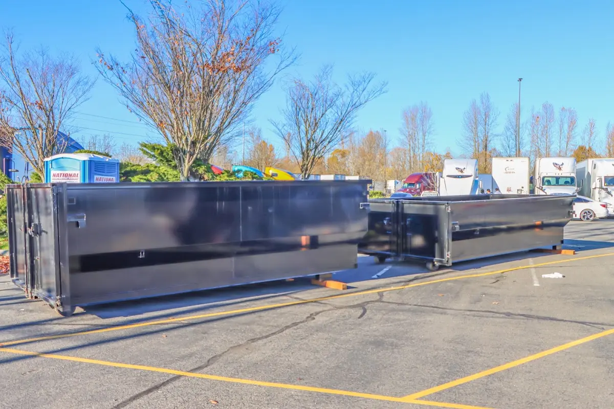 Professional dumpster rental service with roll-off container on residential driveway in Nuevo